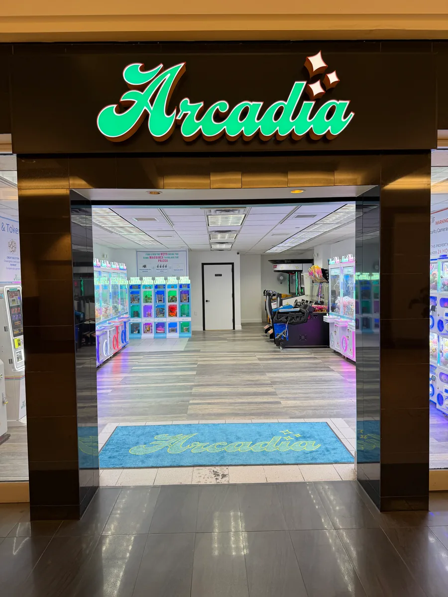 Arcadia storefront with the illuminated script logo above an open entrance to the arcade